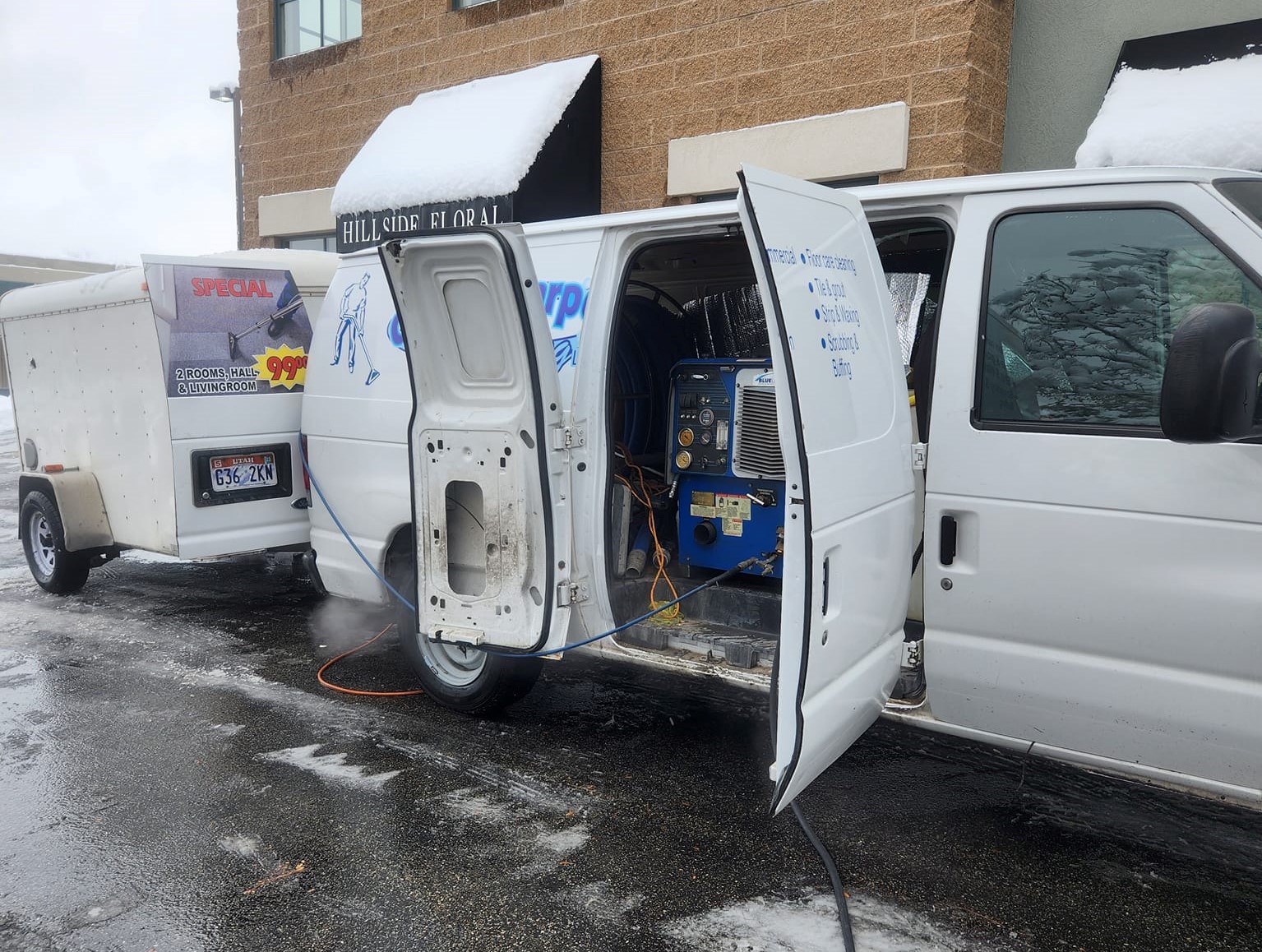 carpet cleaning van with the doors open and hoses being set outside